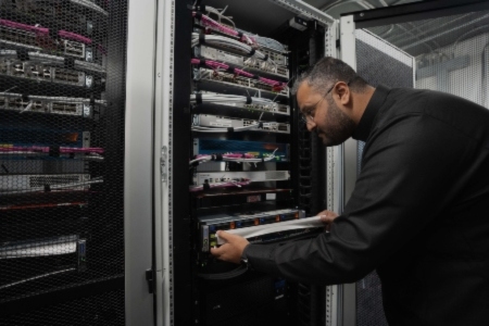 A BAE Systems engineer examines a rack of servers