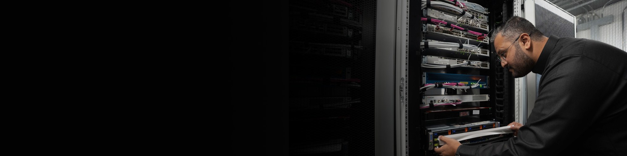 A BAE Systems engineer examines a rack of servers