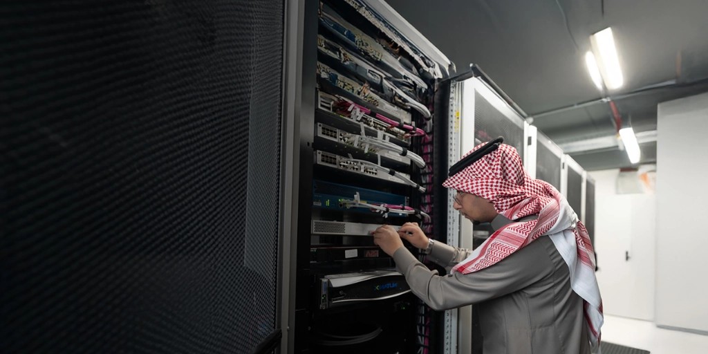A BAE Systems engineer in Saudi Arabia examines a rack of servers